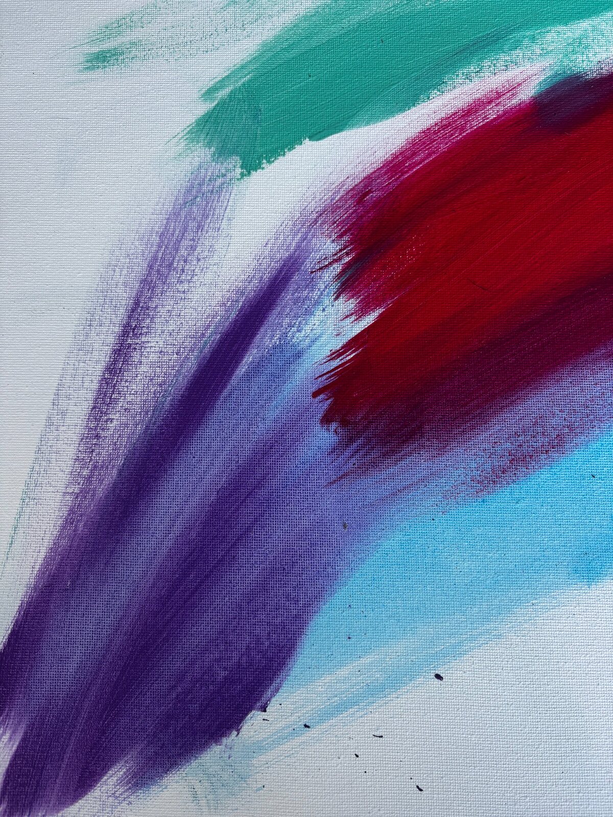Close-up of turquoise, crimson and violet paint on canvas